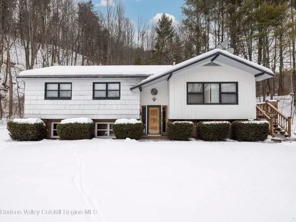 a view of a house with a yard covered in snow