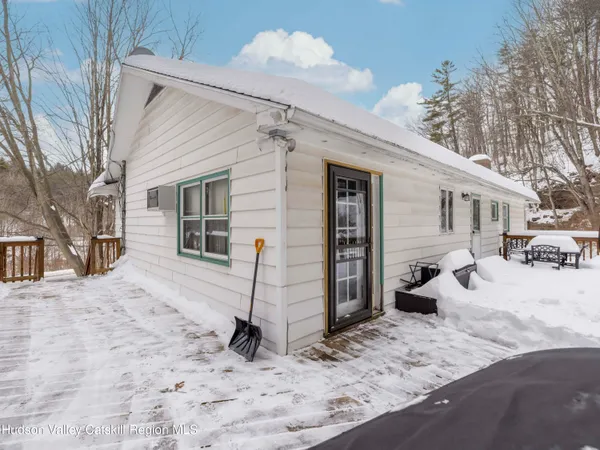 a front view of a house with a yard covered in snow