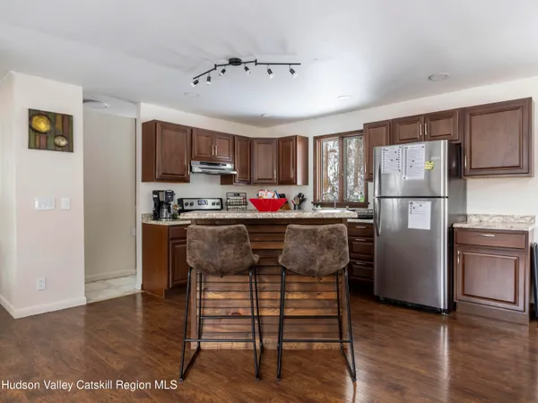 a view of a kitchen with wooden floor and cabinets