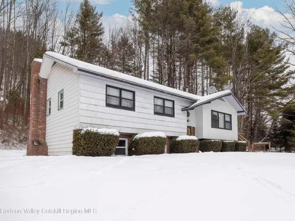a view of a house with a yard covered in snow