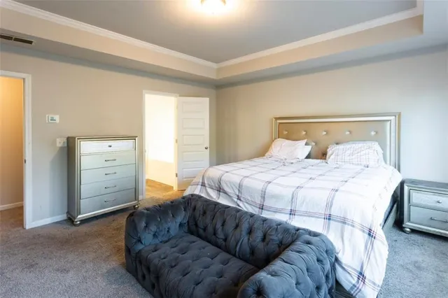 a bedroom with a bed a flat screen tv and a window