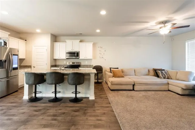 a living room with furniture and kitchen view