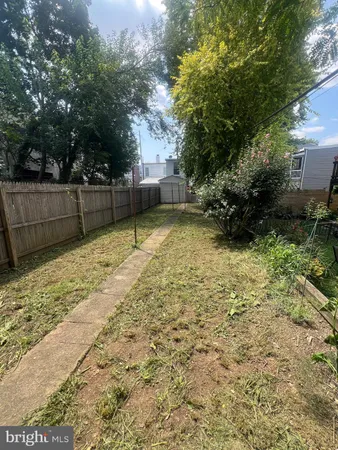 a view of backyard with wooden fence