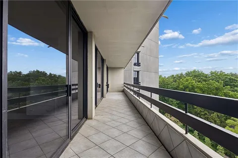 a view of a balcony with chairs and wooden floor