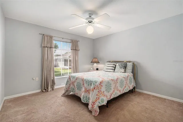 a bed sitting in a spacious bedroom next to a window