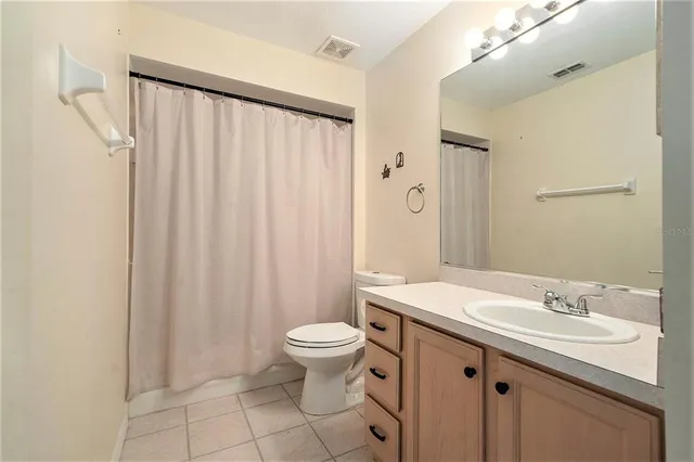 a bathroom with a sink a toilet a mirror and shower curtain
