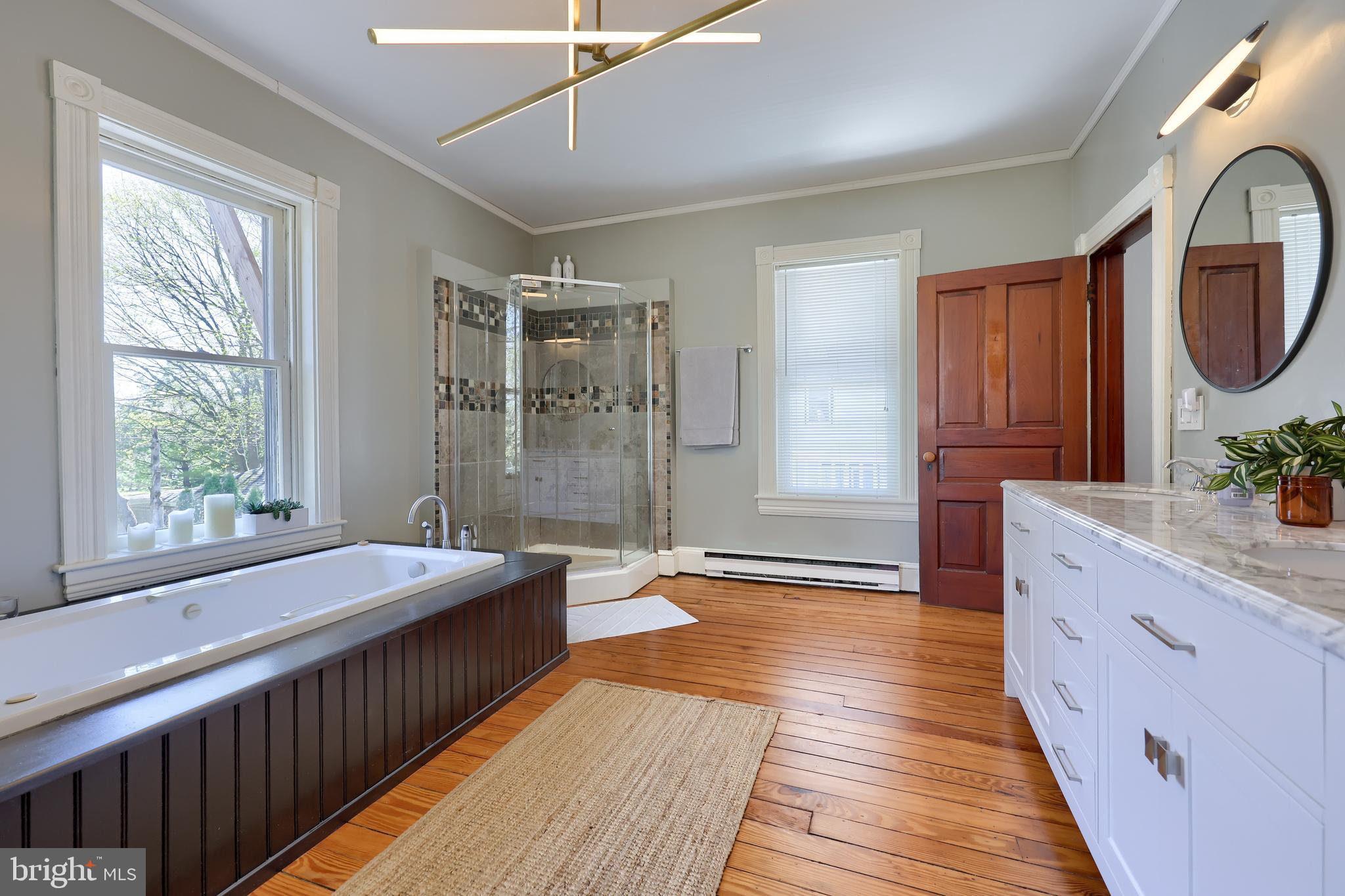 613 South Broad Street Lititz, PA 17543 - Photo 41 of 60 a spacious bedroom with a large bed and a chandelier