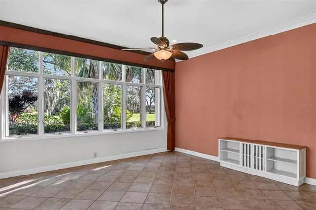 an empty room with windows and ceiling fan