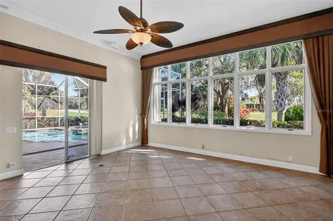 a view of an empty room with wooden floor fan and a window