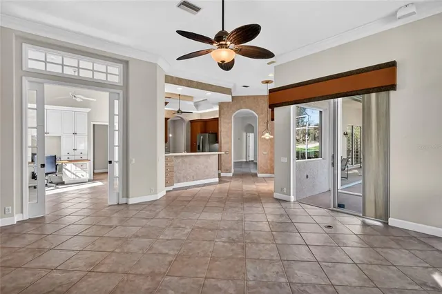 a view of an empty room with wooden floor fan and a window
