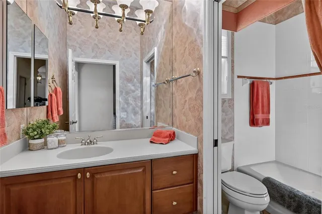 a spacious bathroom with a granite countertop sink a mirror and a bathtub