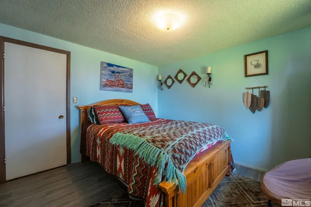 a bedroom with a bed and painting on the wall