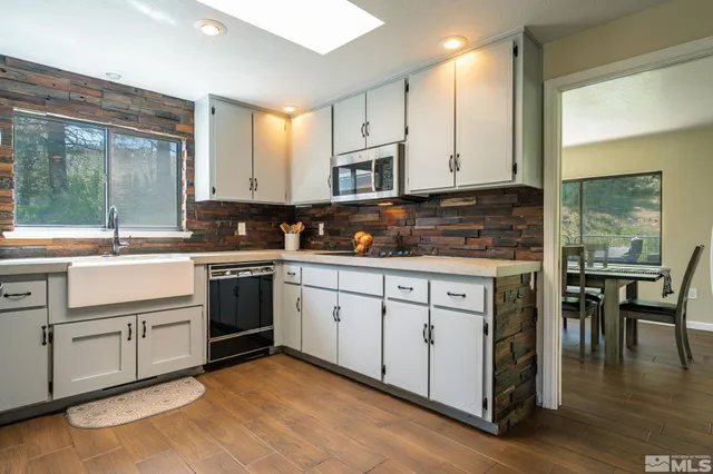 a kitchen with cabinets appliances and a large window