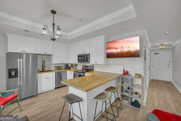 a kitchen with stainless steel appliances a refrigerator sink and microwave
