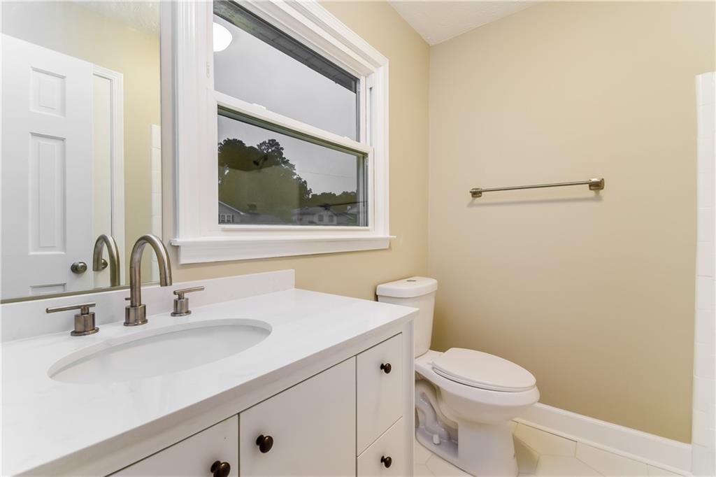 3119 Windfield Circle Tucker, GA 30084 - Photo 13 of 20 a bathroom with a sink a toilet and a mirror