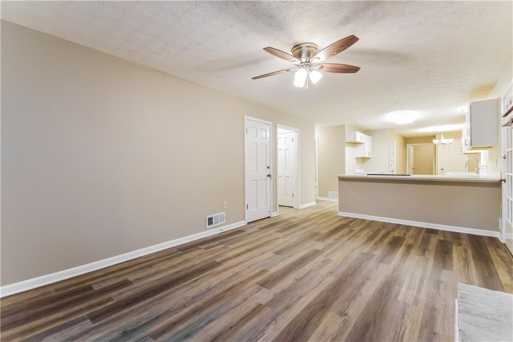 3119 Windfield Circle Tucker, GA 30084 - Photo 6 of 20 a view of an empty room with wooden floor and a ceiling fan