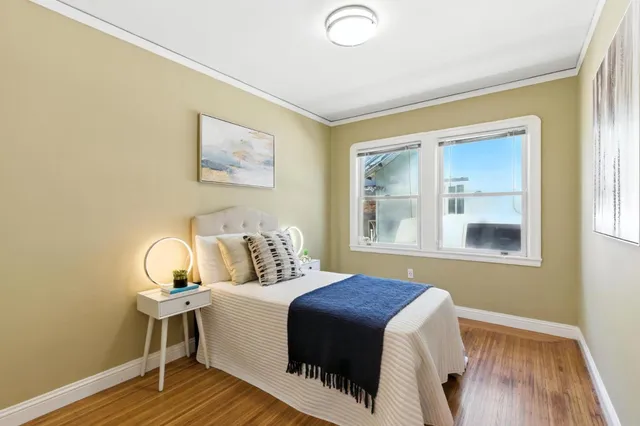 a bedroom with a bed and wooden floor
