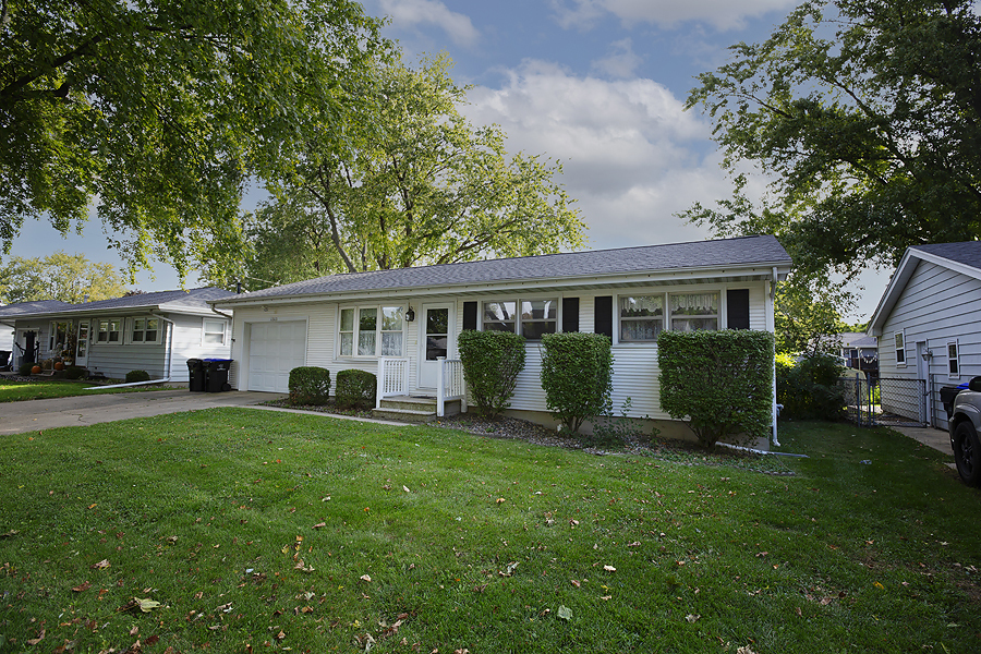 a view of a house with a yard and sitting area
