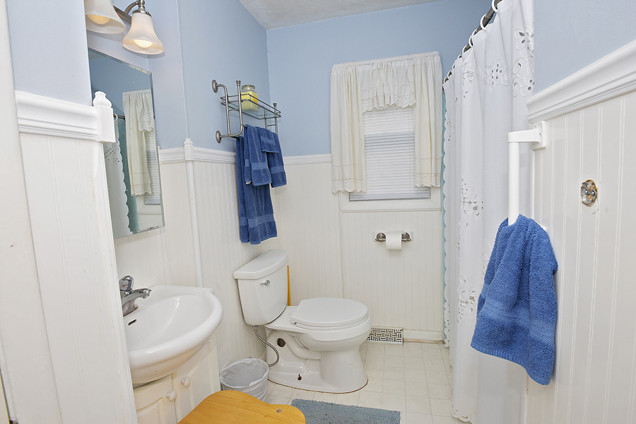 1313 Rutledge Road Bloomington, IL 61704 - Photo 13 of 29 a white toilet sitting next to a bathroom sink and tub