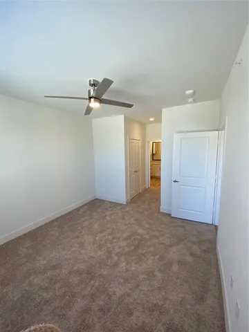 an empty room with an entryway and fan