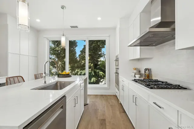 a kitchen with a sink stove top oven and cabinets