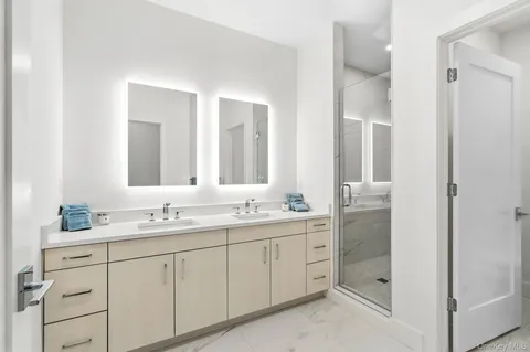 a spacious bathroom with double sink and a mirror