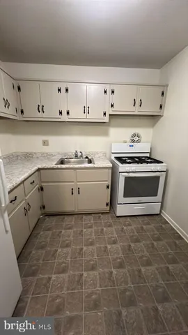 a kitchen with stainless steel appliances a stove a sink and cabinets