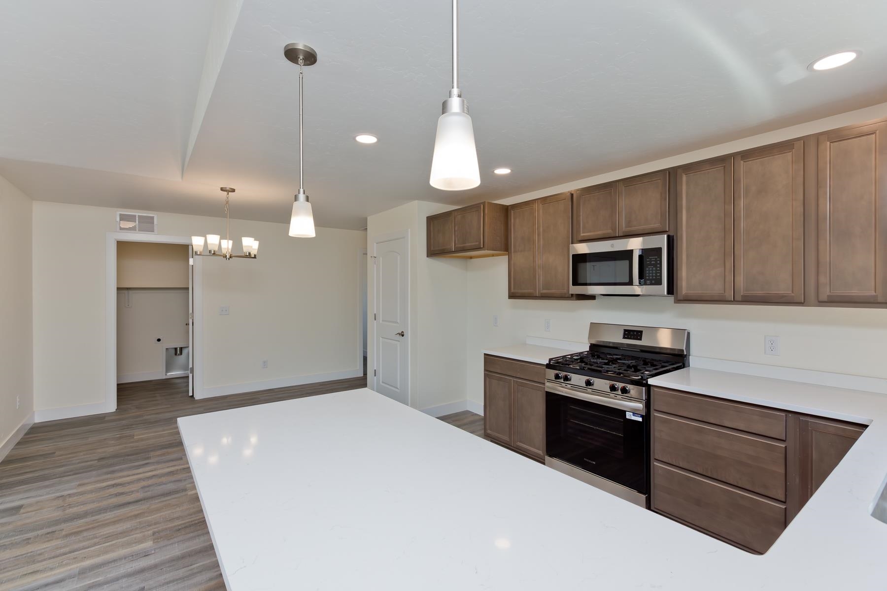 660 Nuvue Street Delta, CO 81416 - Photo 11 of 35 a kitchen with stainless steel appliances kitchen island granite countertop a stove a sink and a microwave