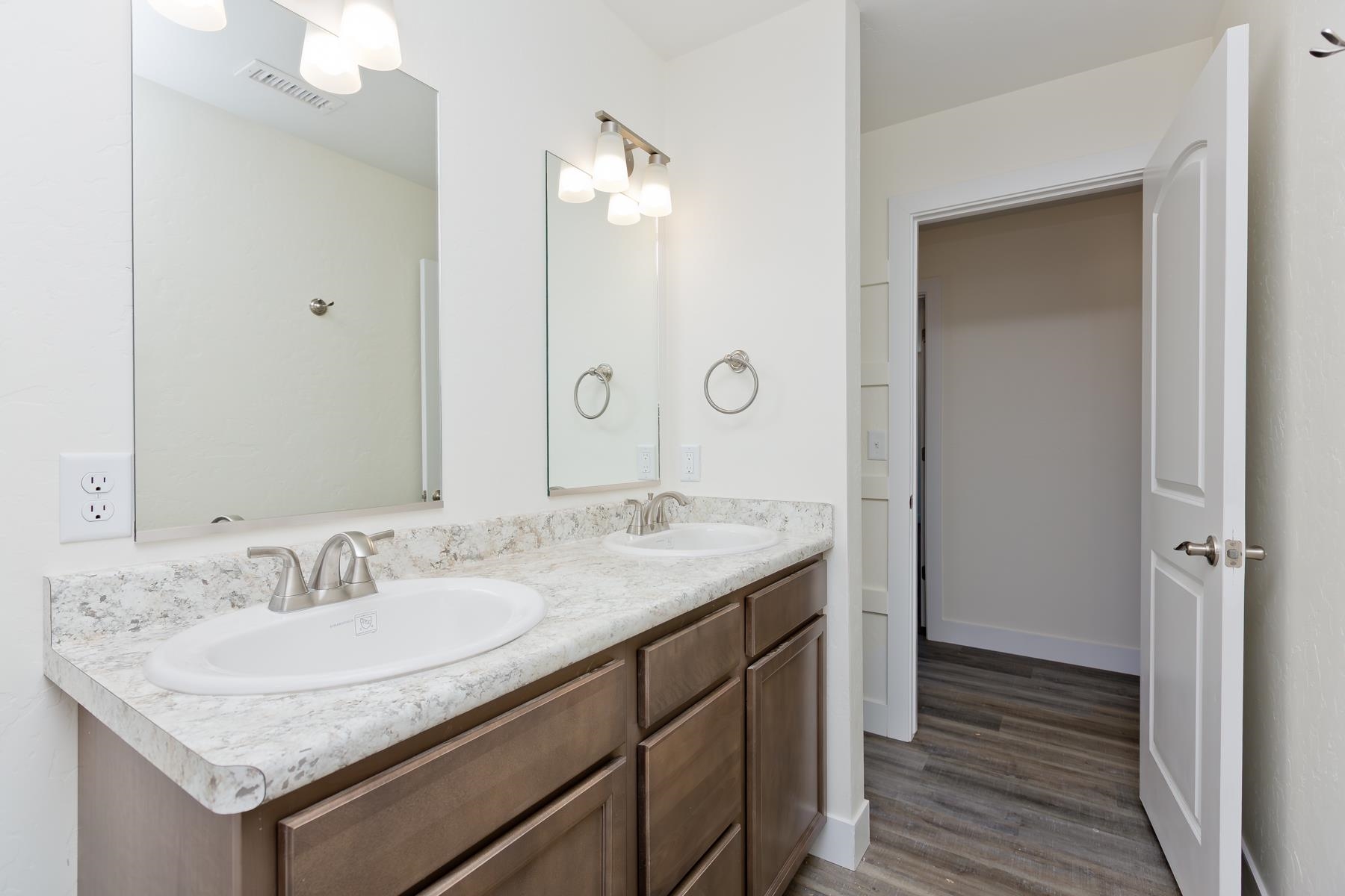 660 Nuvue Street Delta, CO 81416 - Photo 28 of 35 a bathroom with a granite countertop sink a mirror and a shower