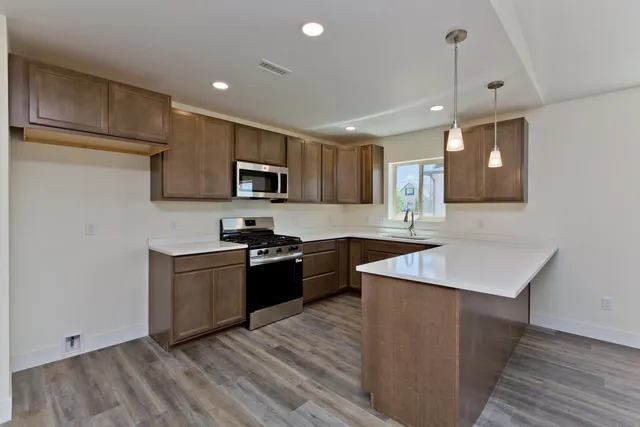 a large white kitchen with a sink and dishwasher