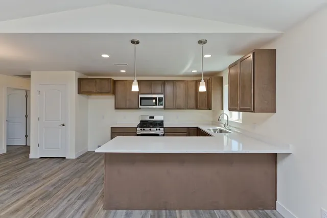 a kitchen with stainless steel appliances granite countertop a sink stove and refrigerator