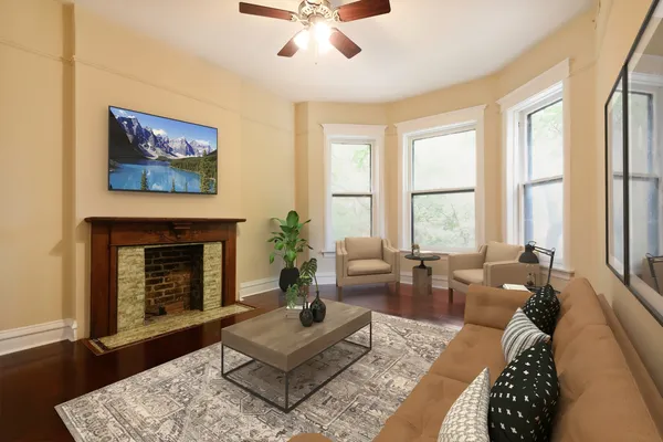 a living room with furniture a fireplace and a large window