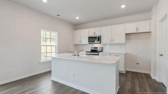 a kitchen with cabinets appliances a sink and a window