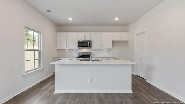 a kitchen with kitchen island a sink wooden floor and a stove