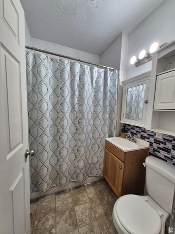 327 North 300 West Logan, UT 84321 - Photo 5 of 12 Full bathroom with vanity, a textured ceiling, backsplash, and shower / tub combo with curtain