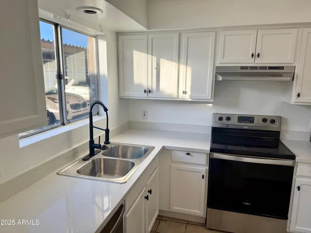 a kitchen with a sink stove and cabinets