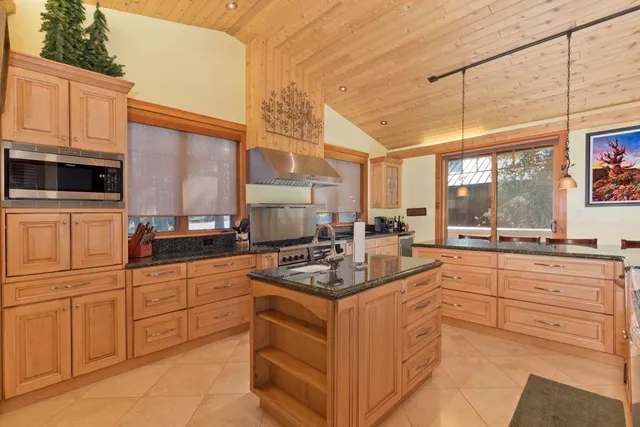 a kitchen with stainless steel appliances granite countertop a stove a sink and a microwave