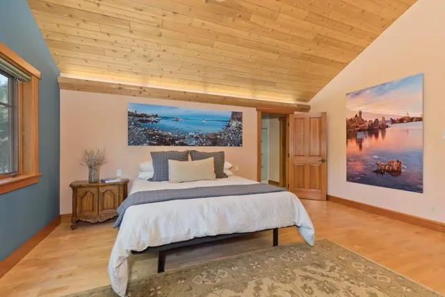 a bedroom with a large bed and a painting on the wall