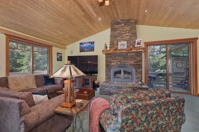 a living room with furniture a fireplace and a large window