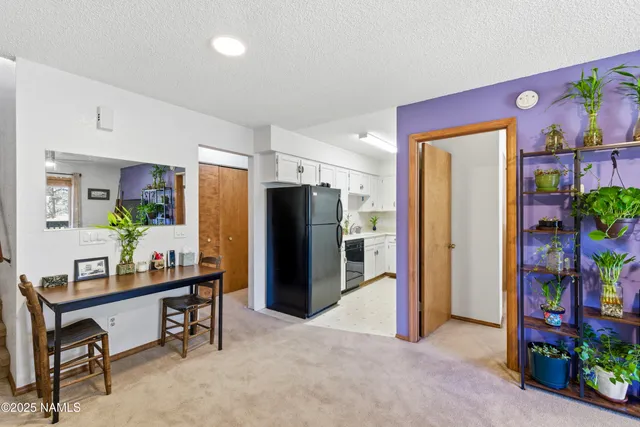 a dining room with furniture and a refrigerator