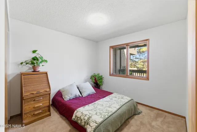 a bedroom with a bed and a potted plant