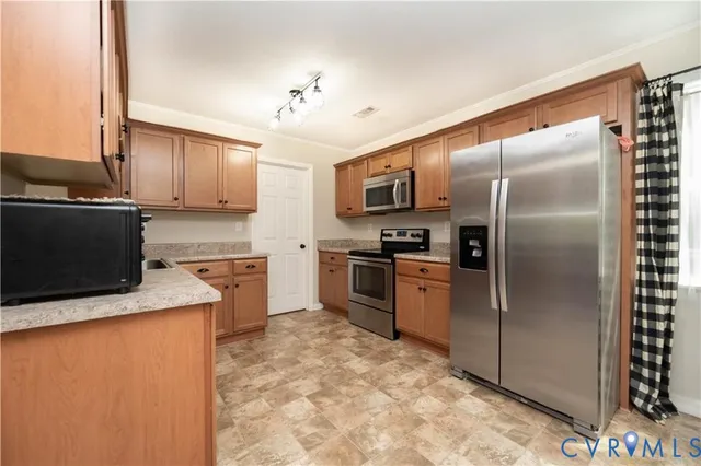 a kitchen with stainless steel appliances granite countertop a refrigerator sink stove and microwave