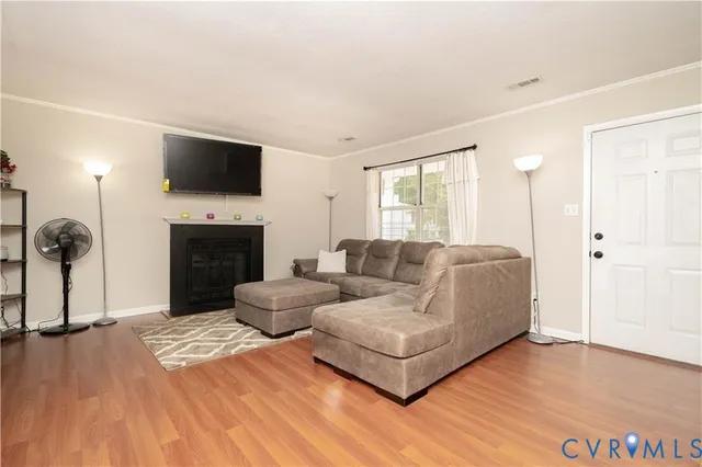 a living room with furniture a flat screen tv and a fireplace