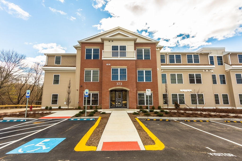 373 Commonwealth Road, Unit 207 Wayland, MA 01778 - Photo 1 of 5 a view of a white building with a swimming pool