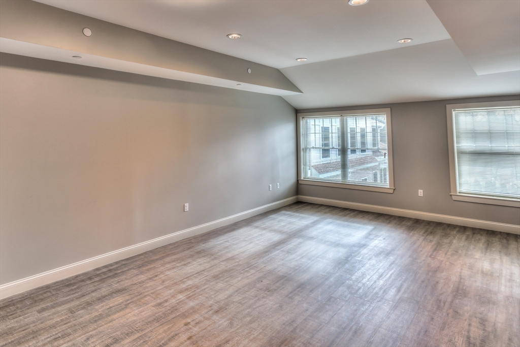 373 Commonwealth Road, Unit 207 Wayland, MA 01778 - Photo 3 of 5 an empty room with wooden floor and windows