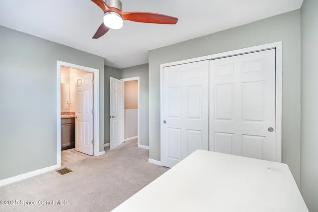 a bedroom with a bed and a chandelier fan