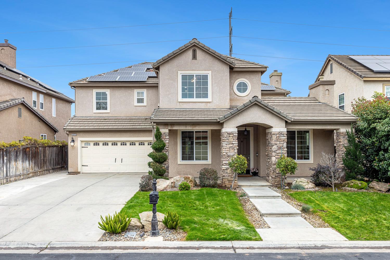 4674 North Arrow Ridge Way Clovis, CA 93619 - Photo 1 of 77 a front view of a house with a yard