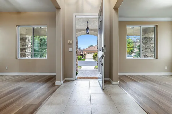 an empty room with wooden floor a fireplace and windows
