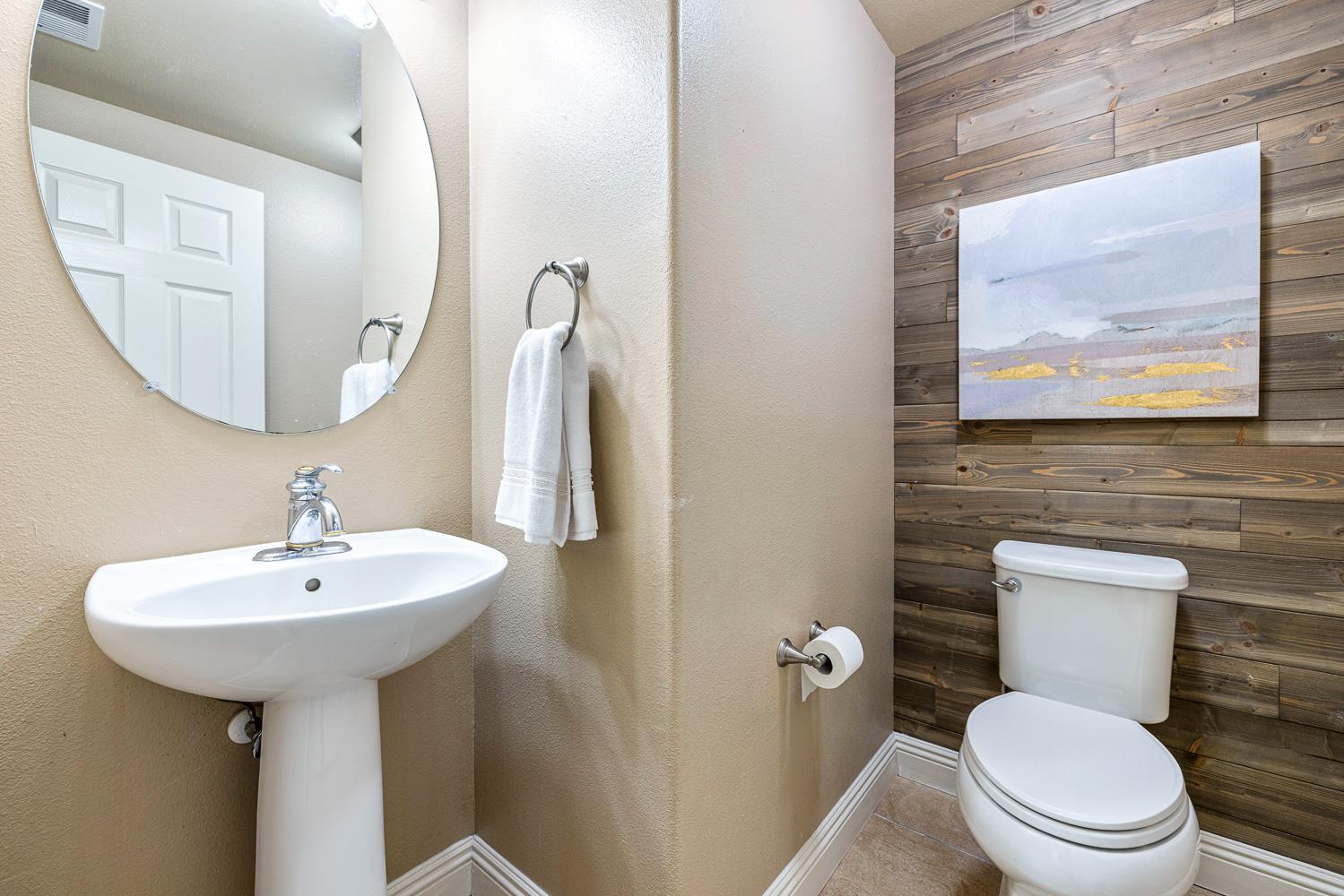 4674 North Arrow Ridge Way Clovis, CA 93619 - Photo 17 of 77 a bathroom with a toilet sink and mirror