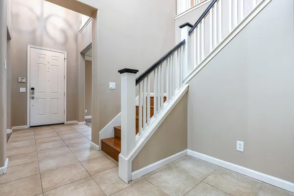 an empty room with wooden floor and a kitchen